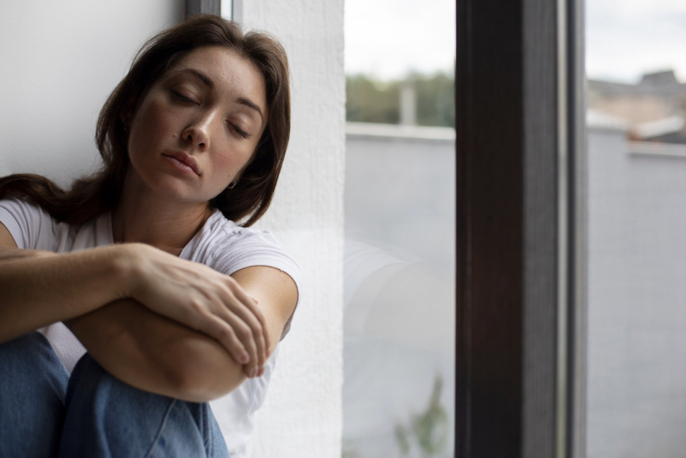 Chica triste en la ventana