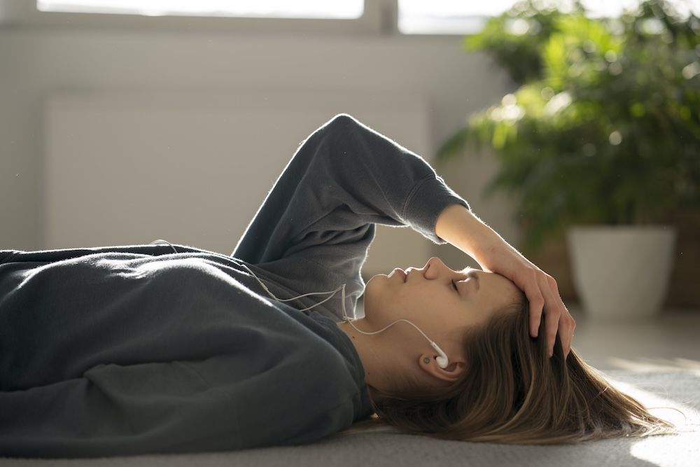 mujer tumbada con ansiedad tocandose la cabeza